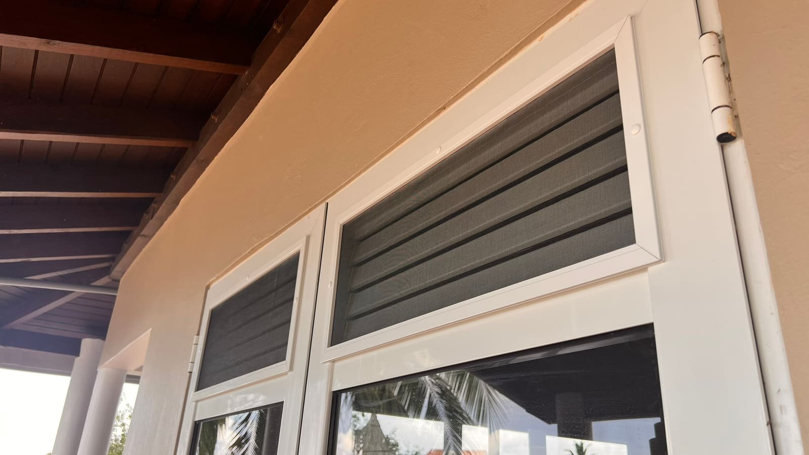 Fixed insect screen on an aluminum door with shutters in Curaçao