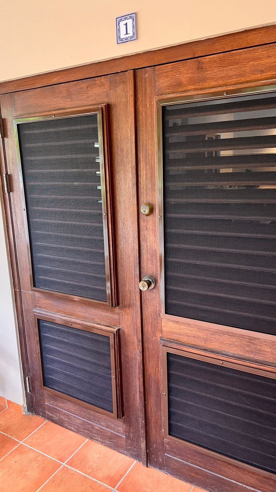 Fixed insect screens on wooden shutter doors in Curaçao