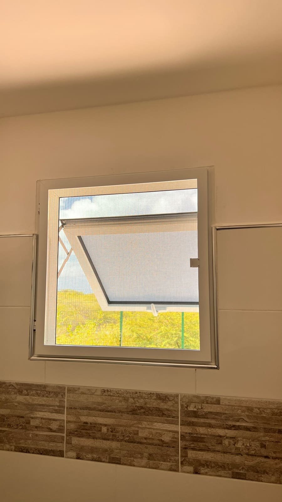 Hinged window screen on its own aluminum frame in Curaçao