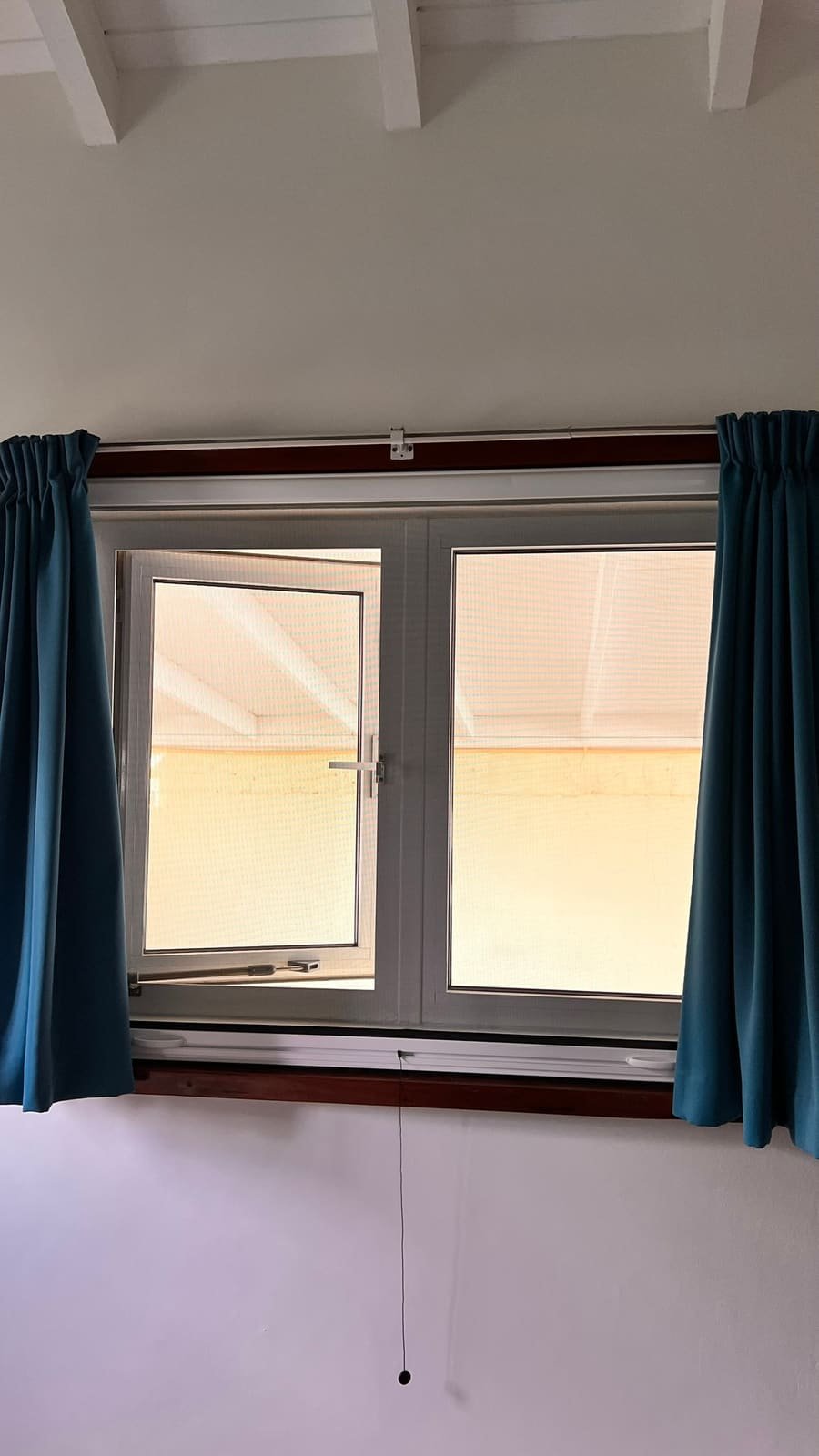 Roll-up window screen, lowered in Curaçao